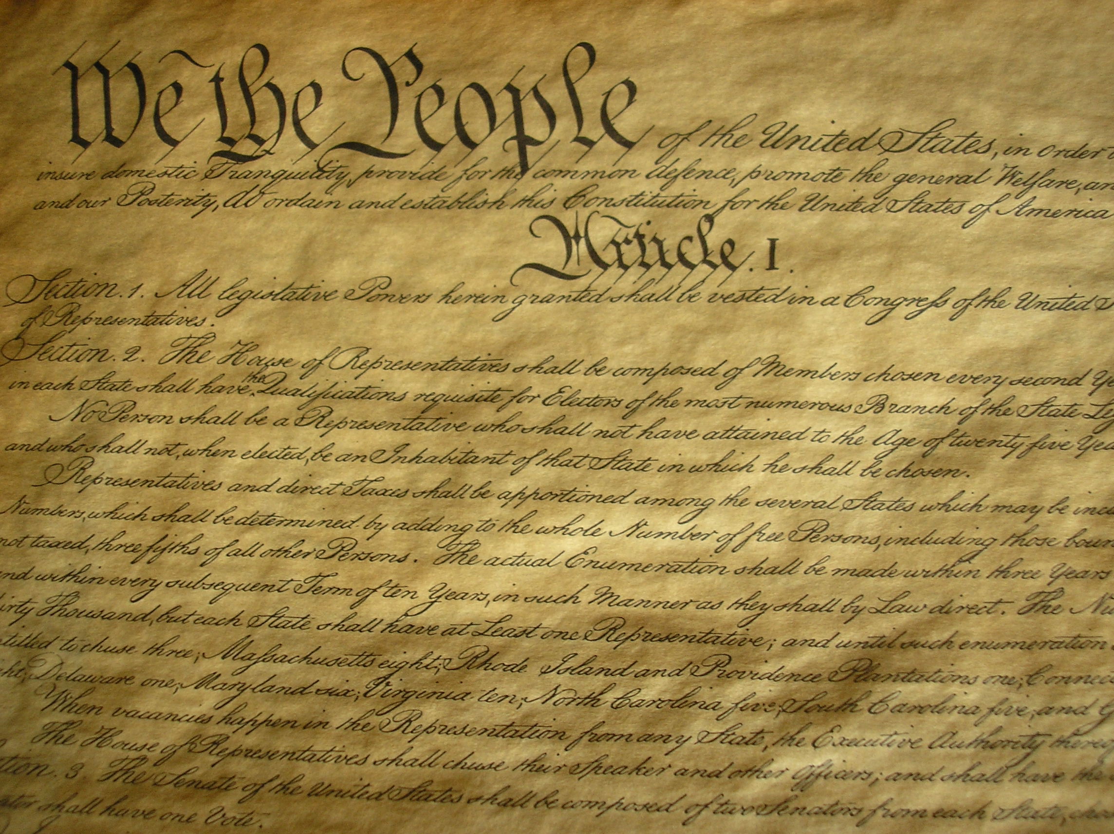 A photo of the first article of the US Constitution. The heading reads, "We The People" followed by paragraphs of body text. 