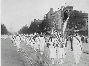 Mostly women, dressed in white shirts, shirts, and hats (faces uncovered) marching in neat rows.