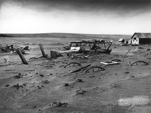 Wagon wheels and an old car buried in dust