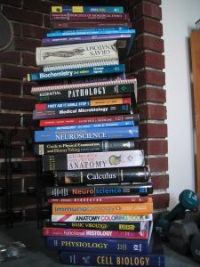 A stack of textbooks, including Anatomy, Calculus, and Cell Biology.