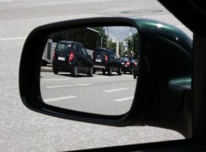 The side mirror of a car looking at parking spots