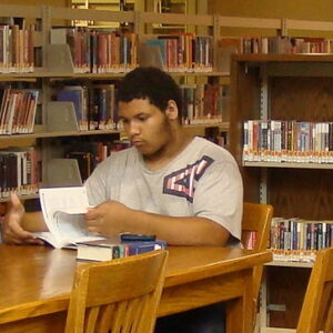 Young man reading at the library