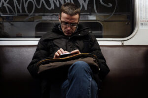 Person on the subway reading on his phone