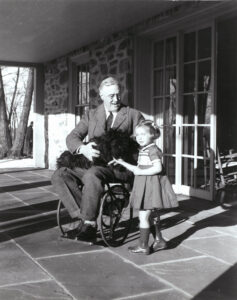 Image depicting FDR in a wheelchair with a dog and young girl.