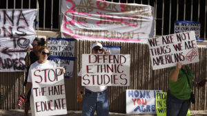 Protesters holding many signs, some of which saying "Defend Ethnic Studies", and "Stop the Hate, Educate".