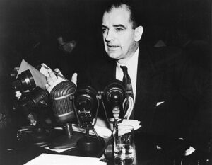 Senator McCarthy in front of press microphones.