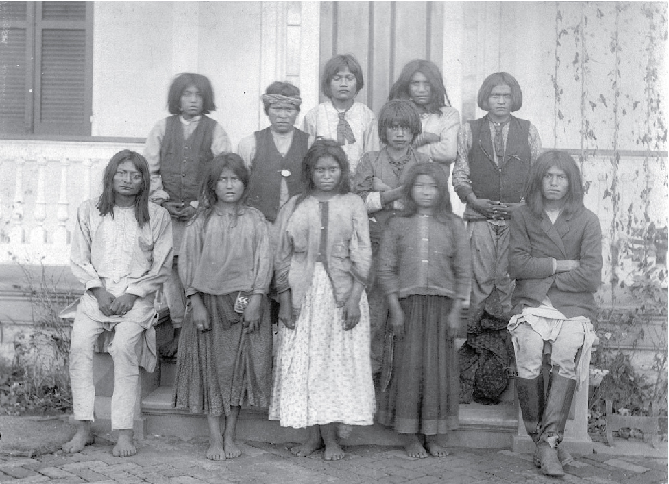 Image of new students at Carlisle school wearing more traditional types of Native clothing.