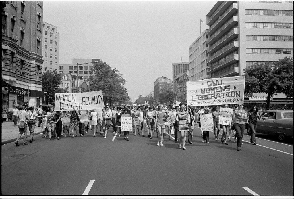 A group of women marching down the street in Washington DC with signs for the Women’s Strike for Equality. The signs read: “Women demand equality”, “I’m a second class citizen”, and “GWU, Women’s Liberation. Students, employees, faculty, wives, neighbors”. 