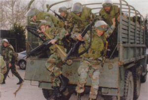 The military jumping off of a truck to begin fighting.