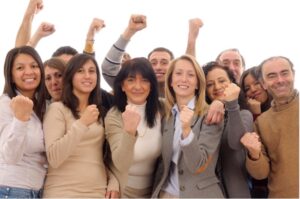 Lots of people in business clothes holding their fists up