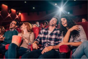 People smiling and laughing in a movie theater