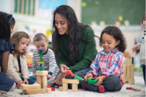 A woman and children playing with blocks