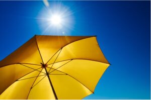 A yellow umbrella under a sunny sky.