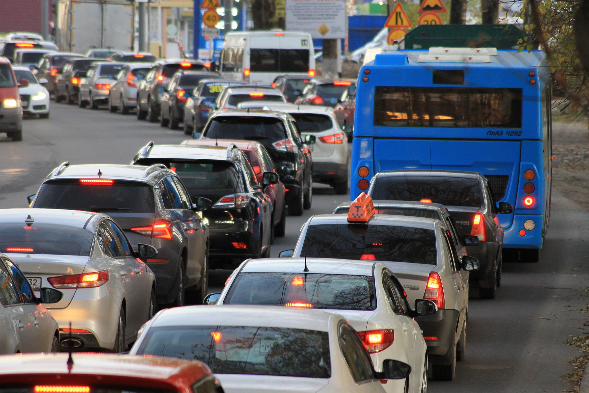 Cars lined up stopped with brake lights on in a traffic jam.