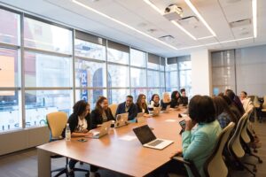 people sitting around a conference table each with a laptop