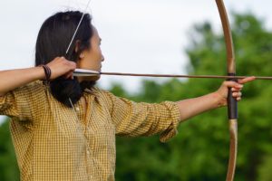 Person holding a bow with an arrow in position to release. 