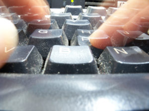 A computer keyboard and fingers.