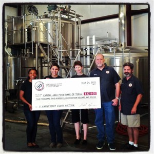 Rogness presents a $2214 check to the Capital Area Food Bank of Texas.
