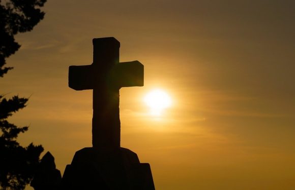 Cement Cross with Rising Sun in the background