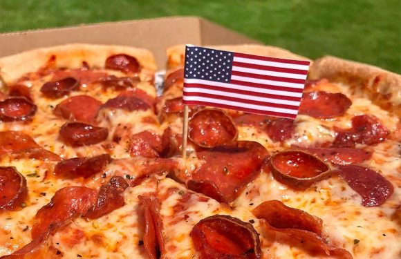 Pepperoni Pizza photo with an American flag on a toothpick, stuck into the pizza