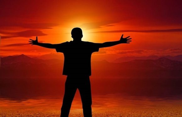 Silhouette arms outstretched against sunset
