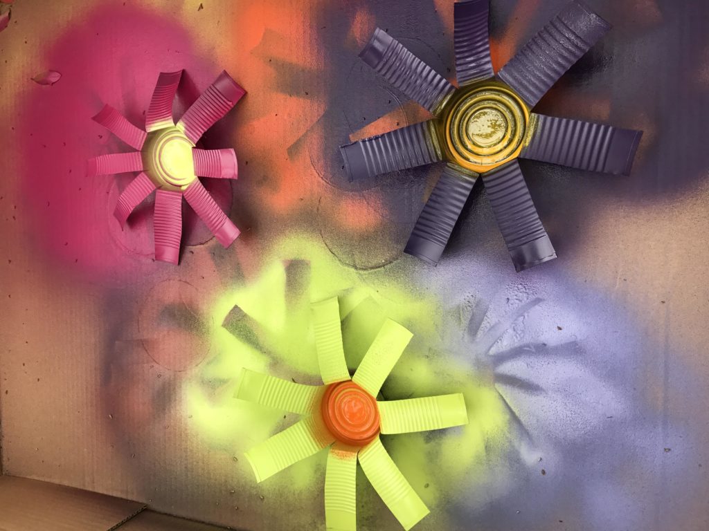 Second layer of paint, painting the centers of the flowers which are the can bottoms