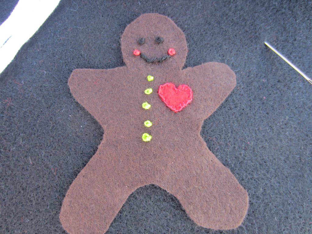 Eye, mouth and buttons added to the gingerbread ornament