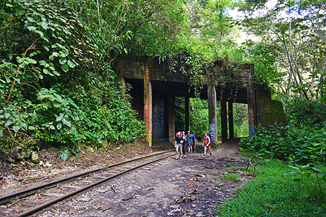 Viajeros caminando bajo puente en la selva peruana