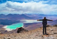 Viajero frente a paisaje desértico y laguna turquesa