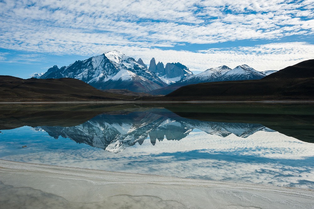 Laguna que refleja montañas al fondo