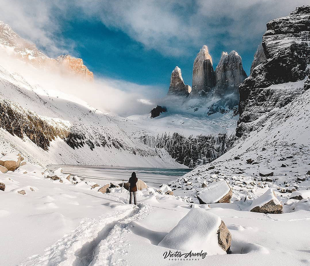 Viajera observando paisaje montañoso y nevado en Base Torres