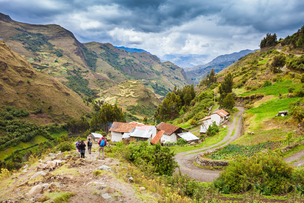 vaqueria-santacruz Viajeros caminan por paisaje agrícola en trekking santa cruz