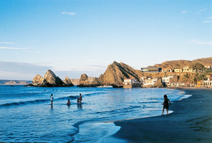 Personas bañándose en playa de Piura
