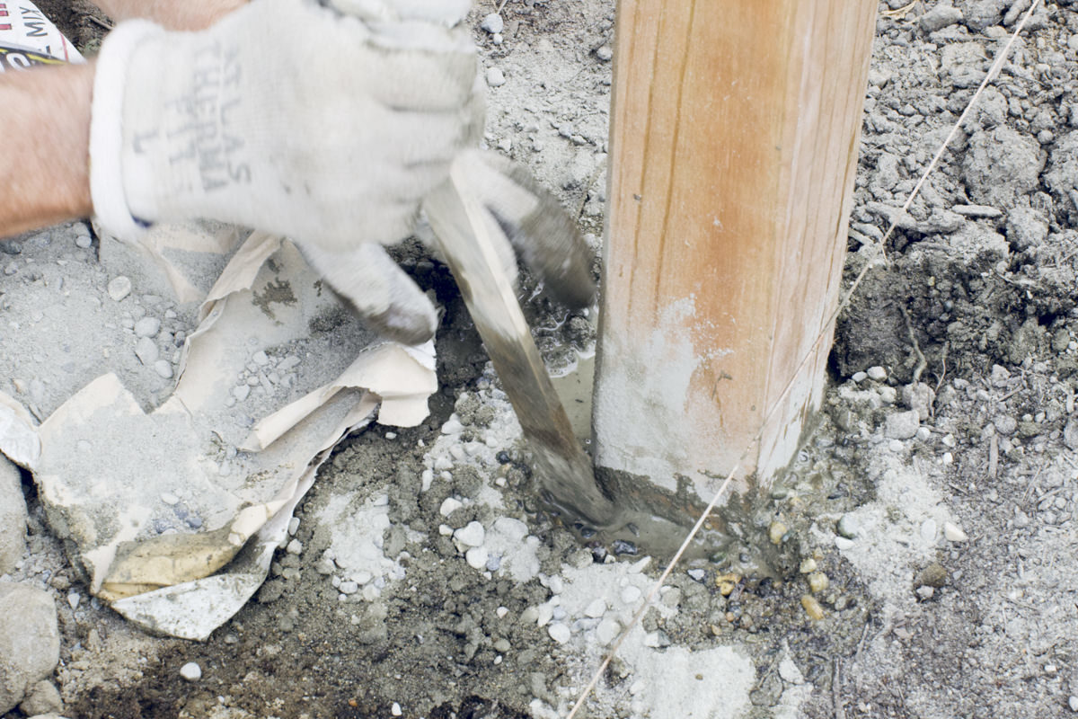 stirring concrete in fence post hole stirring concrete in fence post hole