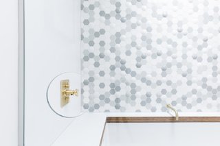 A thoughtful cut-out in the glass enclosure allows people to reach the faucet without being sprayed by the shower. "It's a bit of a signature for us," Horner remarks.