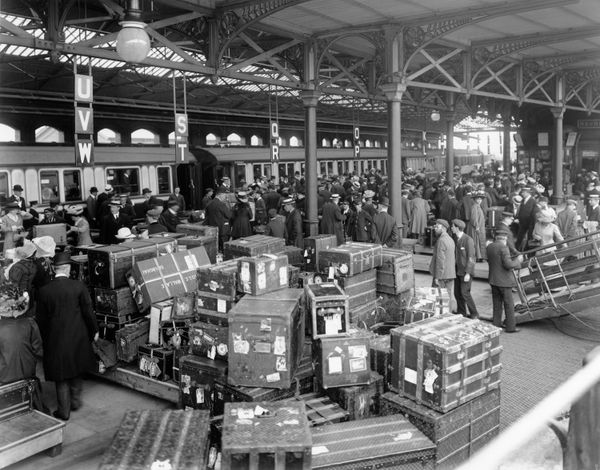 In England, passengers identify their luggage as they disembark the SS Cedric and ready to join a waiting boat train.