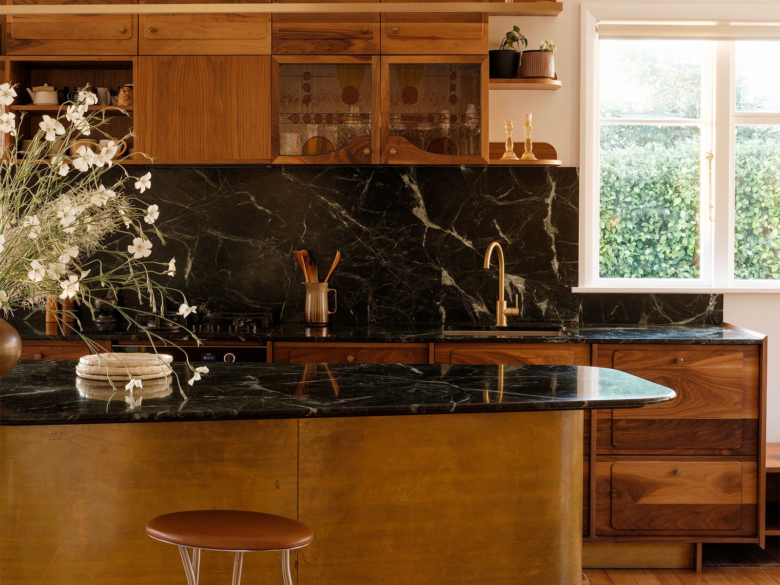 Atelier Jones Design embellished stained glass, terra-cotta tile, and walnut cabinets with a floral motif inspired by kōwhai pods.
