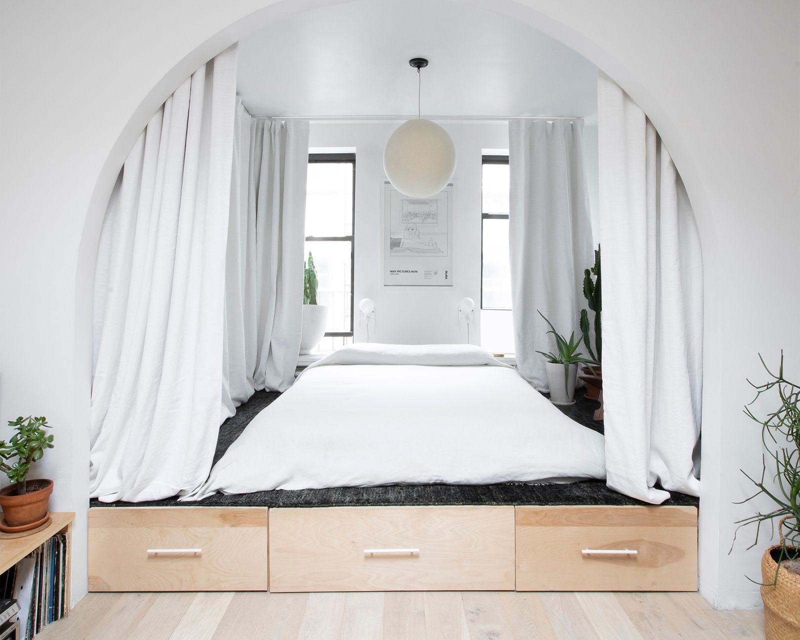 Millwork conceals everything from kitchen appliances to a washer and dryer, and even elevates the bedroom to create distinction in the small space.