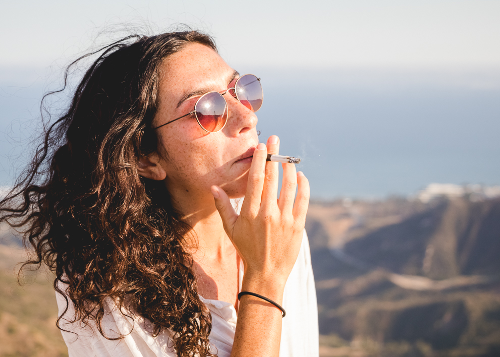 Image of a woman smoking a prerolled marijuana joint