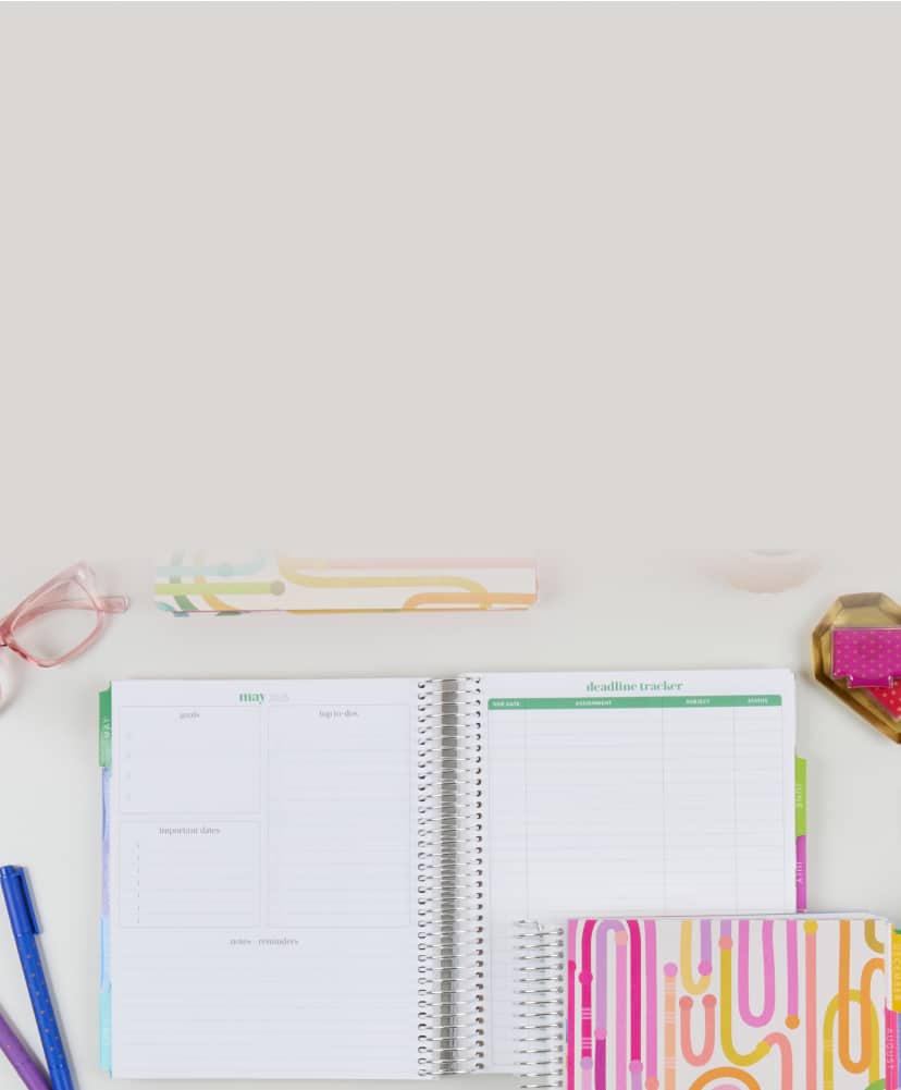 Open and closed colorful academic planners in a variety of form factors. Complementary accessories including pens, notepads and pencil case surround the planners.