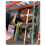 A vintage Harley Davidson sign as well as a welders table.
