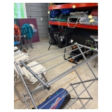 A small potion of camping equipment incuding a drying rack and chairs.