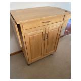 Wood butcher block kitchen cart with drop leaf in a natural finish