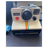 a vintage Polaroid OneStep Land Camera, known for its iconic rainbow stripe. It was the flagship mod