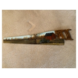 a hand-painted antique or vintage hand saw, a piece of folk art used as rustic home decor. 