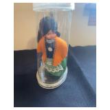 vintage hard plastic doll, possibly an Irish souvenir doll, is fixed to the base of its display case