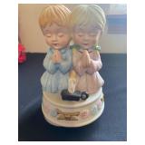 a vintage ceramic musical figurine featuring a boy and girl praying. 