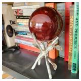 vintage decorative orb, likely glass or stone, displayed in a wrought iron holder. 