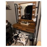 rustic brown industrial-style makeup vanity set with a lighted mirror and cow print stool