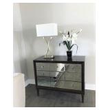 Small mirrored front dresser, lamp and home decor.